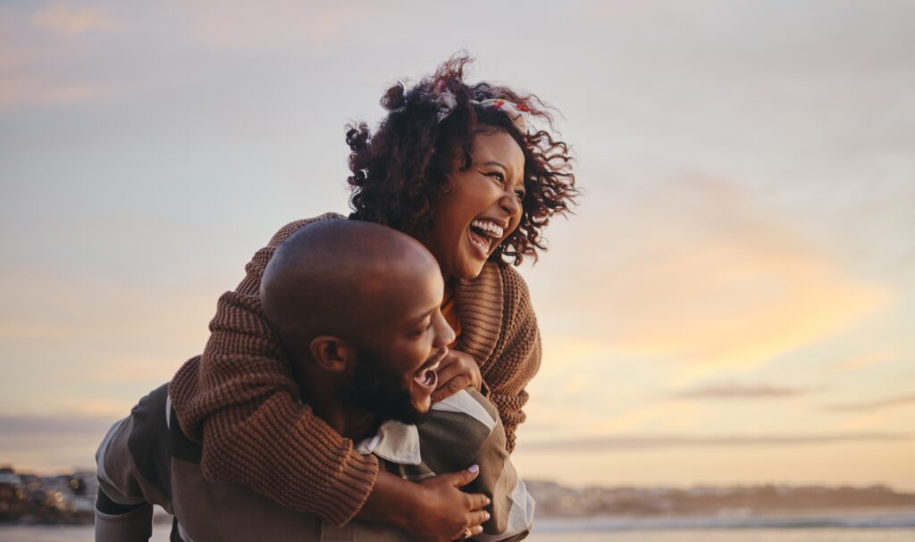 Couple smiling and hugging on beach